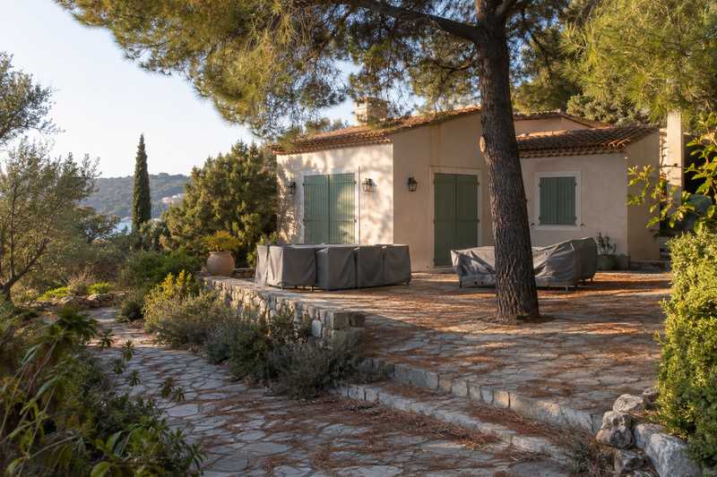 Résidence secondaire aux volets clos, mobilier de jardin sous des housses